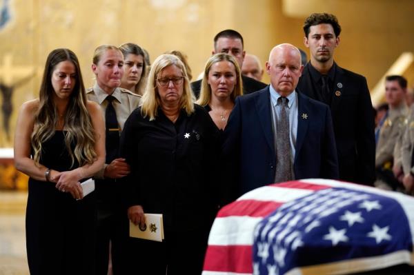Relatives and peers of Ryan Clinkunbroomer look on during the funeral service for the deputy.