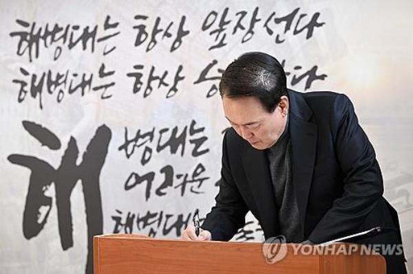 President Yoon Suk Yeol writes in a guestbook during a visit to the Marine Corps 2nd Division in Gimpo, just west of Seoul, on Feb. 10, 2024, on the Lunar New Year holiday, in this photo provided by the presidential office. (PHOTO NOT FOR SALE) (Yonhap)