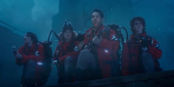 Finn Wolfhard, Carrie Coon, Paul Rudd, and Mckenna Grace stand on a rooftop with proton packs in Ghostbusters: Frozen Empire.
