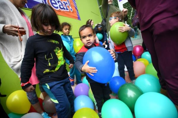 Youngsters collect balloons during the Noon Year’s Eve event at...