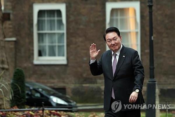 President Yoon Suk Yeol waves as he arrives at 10 Downing Street in Lo<em></em>ndon on Nov. 22, 2023. (Pool photo) (Yonhap)