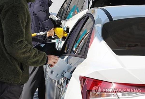 This file photo taken Feb. 12, 2024, shows people pumping gas at a gas station in Seoul. (Yonhap)