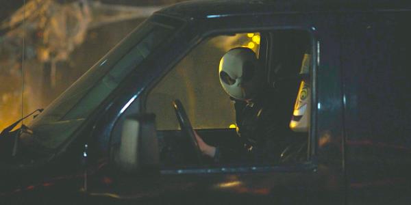 A man in a Jack Skellington mask leans forward in a car to peer through the side window in Fargo season 5