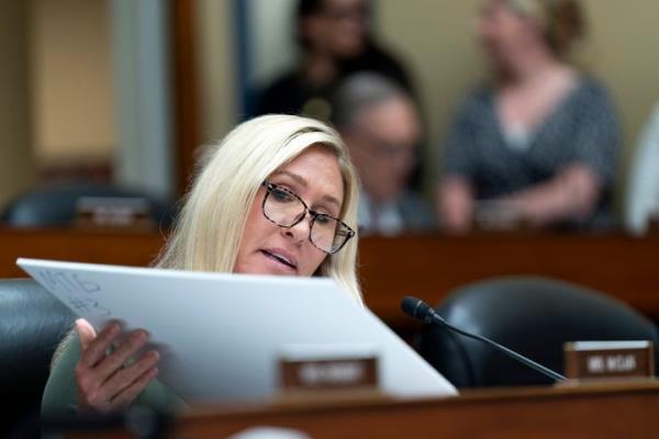 Rep. Marjorie Taylor-Greene (R-Ga.) prepares to hold up explicit images and an airline co<em></em>nfirmation made by Hunter Biden during a House Oversight and Accountability Committee hearing on Wednesday. Hunter Biden's attorney has since called on the Office of Co<em></em>ngressional Ethics to “prom<em></em>ptly and decisively co<em></em>ndemn and discipline” Greene over the naked picture showcase.