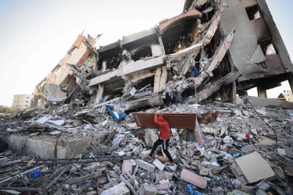 Palestinians search for salvageable items in the rubble of a destroyed building in Al-Zahra on the southern outskirts of Gaza City. — AFP pic