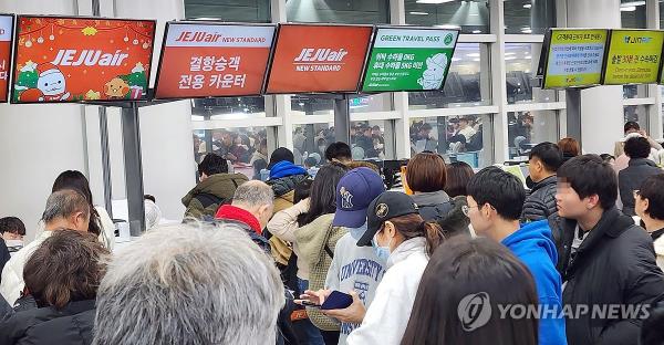 Passengers line up at check-in points at Jeju Internatio<em></em>nal Airport on the southern resort island of Jeju after flights were canceled or delayed due to a snowstorm, in this photo taken Dec. 21, 2023. (Yonhap)