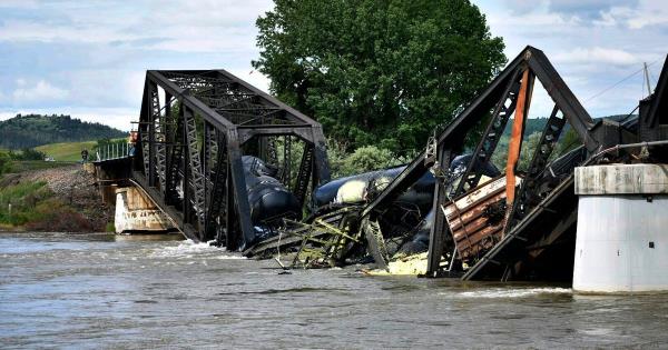Several train cars are immersed in the Yellowstone River after a bridge collapse near Columbus, Mont., on Saturday, June 24, 2023. The bridge collapsed overnight, causing a train that was traveling over it to plunge into the water below. (AP Photo/Matthew Brown)