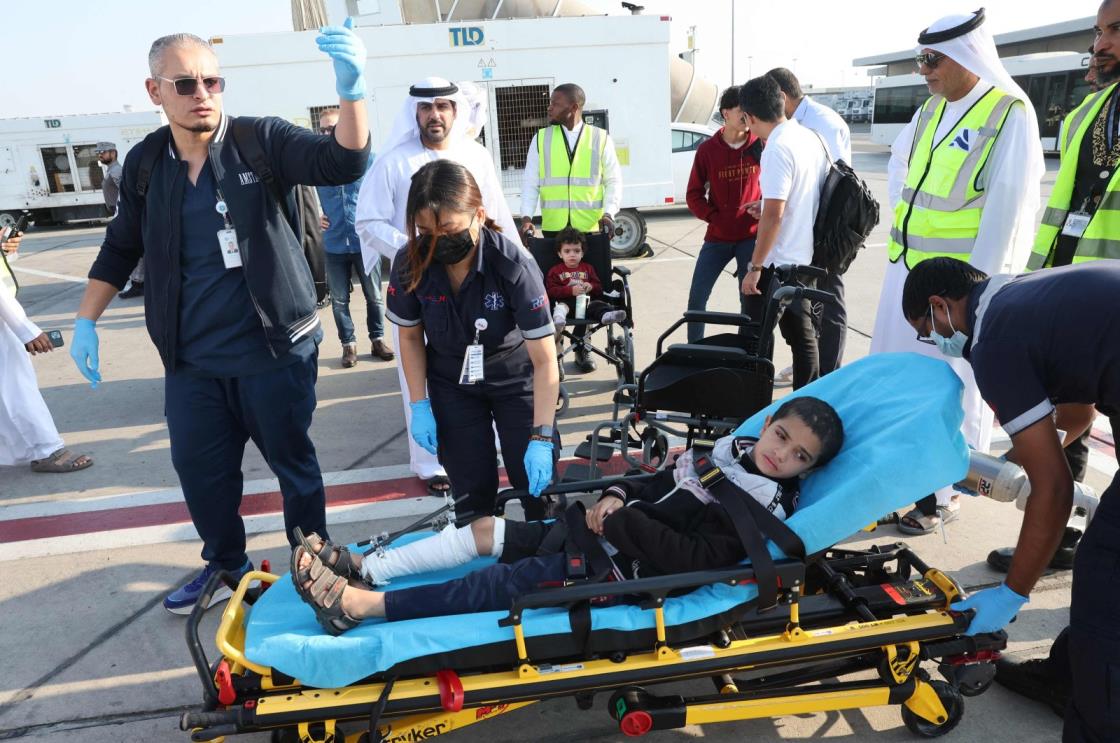 Volunteers transport Palestinian children wounded in the o<em></em>ngoing Israeli attacks on Gaza off a plane upon their arrival in Abu Dhabi, UAE, Nov. 18, 2023. (AFP Photo)
