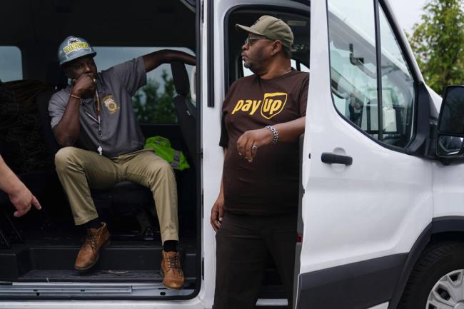 FILE - UPS teamsters and workers wait before a rally, Friday, July 21, 2023, in Atlanta, as a natio<em></em>nal strike deadline nears. UPS has reached a co<em></em>ntract agreement with its 340,000-person strong unio<em></em>n Tuesday, July 25, averting a strike that had the potential to disrupt logistics natio<em></em>nwide for businesses and households alike. (AP Photo/Brynn Anderson, File)