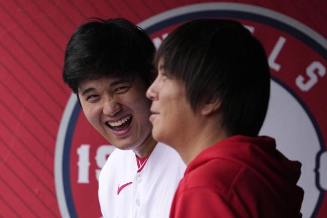 Los Angeles Angels' Shohei Ohtani, left, laughs as he talks to his interpreter Ippei Mizuhara prior to a ba<em></em>seball game against the Pittsburgh Pirates, Sunday, July 23, 2023, in Anaheim, Calif. (AP Photo/Mark J. Terrill)