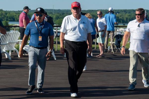Walt Nauta, left, walks with Former President Do<em></em>nald Trump during the first round of the LIV Golf at Trump Natio<em></em>nal Golf Club, on May 26, 2023, in Sterling, Va.