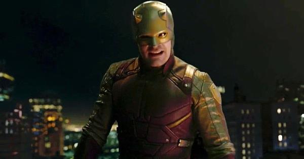 Daredevil wearing his yellow and red suit in She-Hulk: Attorney at Law, standing on top of a parking garage with the city behind him.