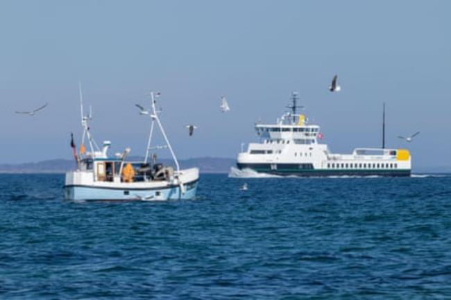 Ferry at sea with fishing boat in foreground